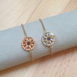 Adjustable bracelet with gold/blue flower design on gold chain