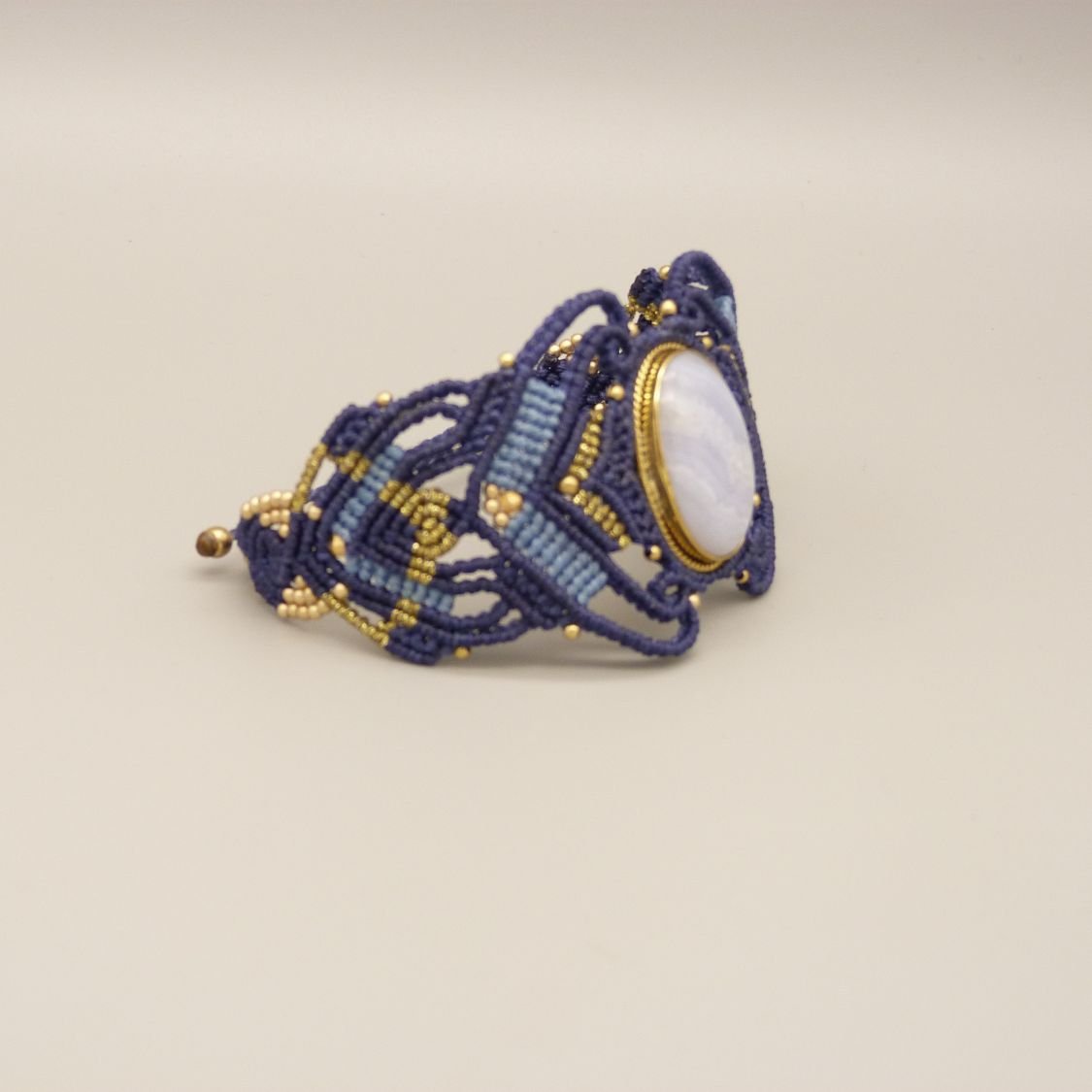 Midnight blue micro-macramé bracelet with a ribbon agate set in gold metal