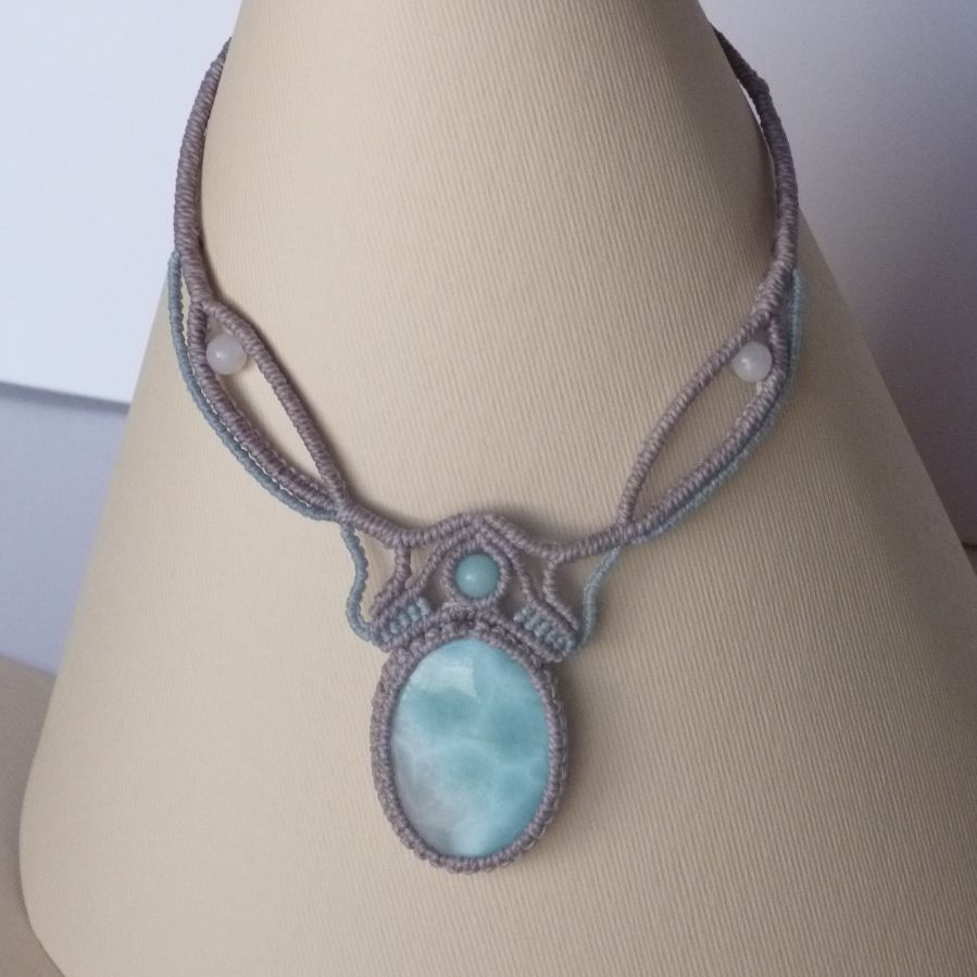 Necklace in taupe gray/frosted blue micro-macramé with a natural gemstone in soft shades of white and light blue in the center.