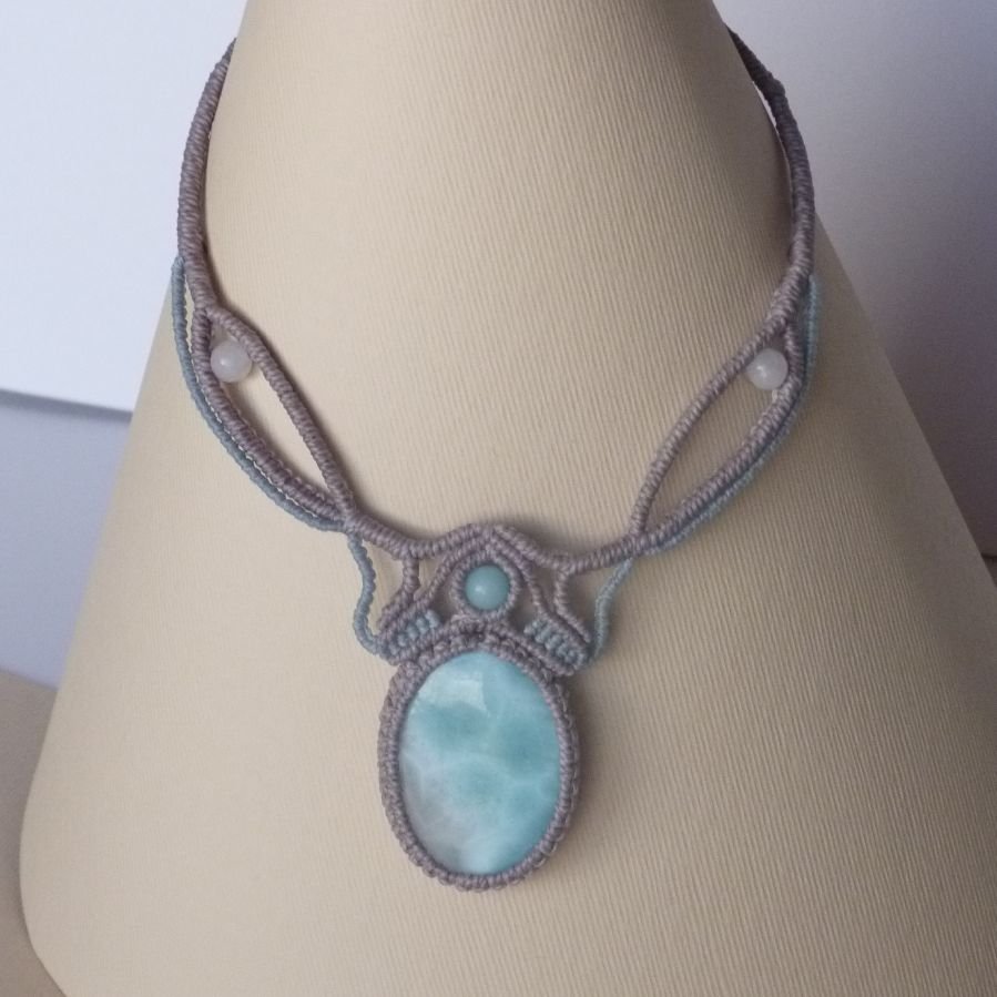 Necklace in taupe gray/frosted blue micro-macramé with a natural gemstone in soft shades of white and light blue in the center.