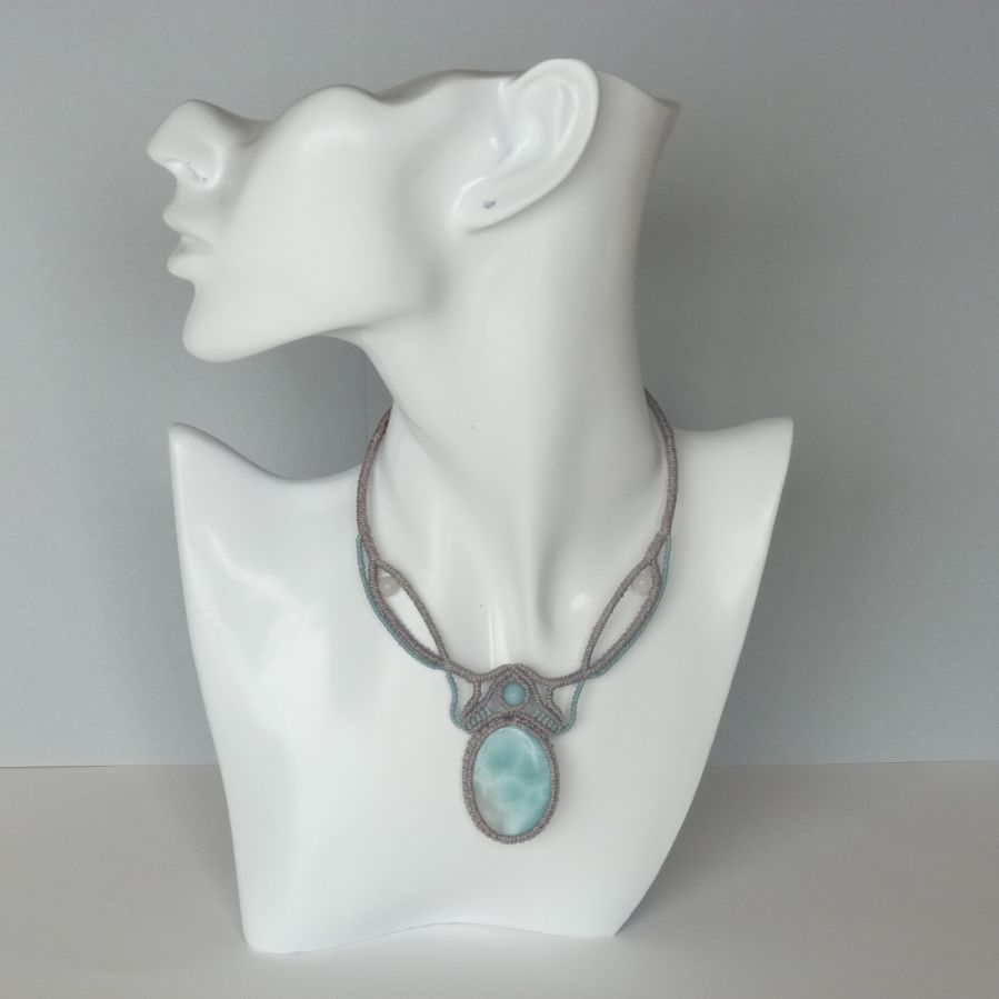 Necklace in taupe gray/frosted blue micro-macramé with a natural gemstone in soft shades of white and light blue in the center.