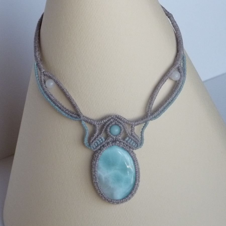 Necklace in taupe gray/frosted blue micro-macramé with a natural gemstone in soft shades of white and light blue in the center.