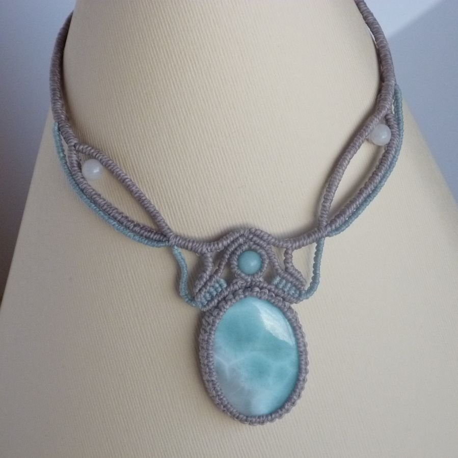 Necklace in taupe gray/frosted blue micro-macramé with a natural gemstone in soft shades of white and light blue in the center.