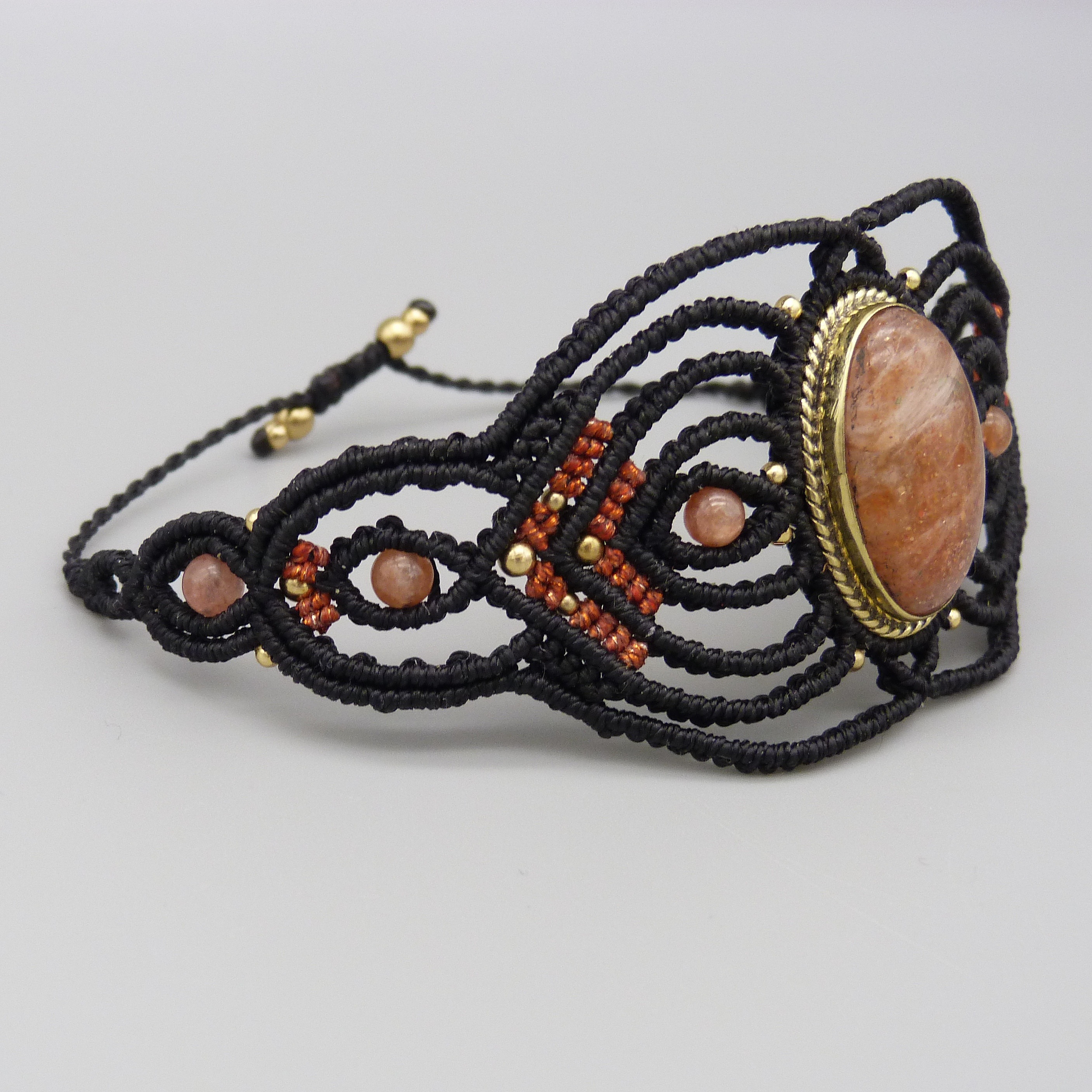 Manchette noire en micro-macram&eacute; avec une pierre de soleil