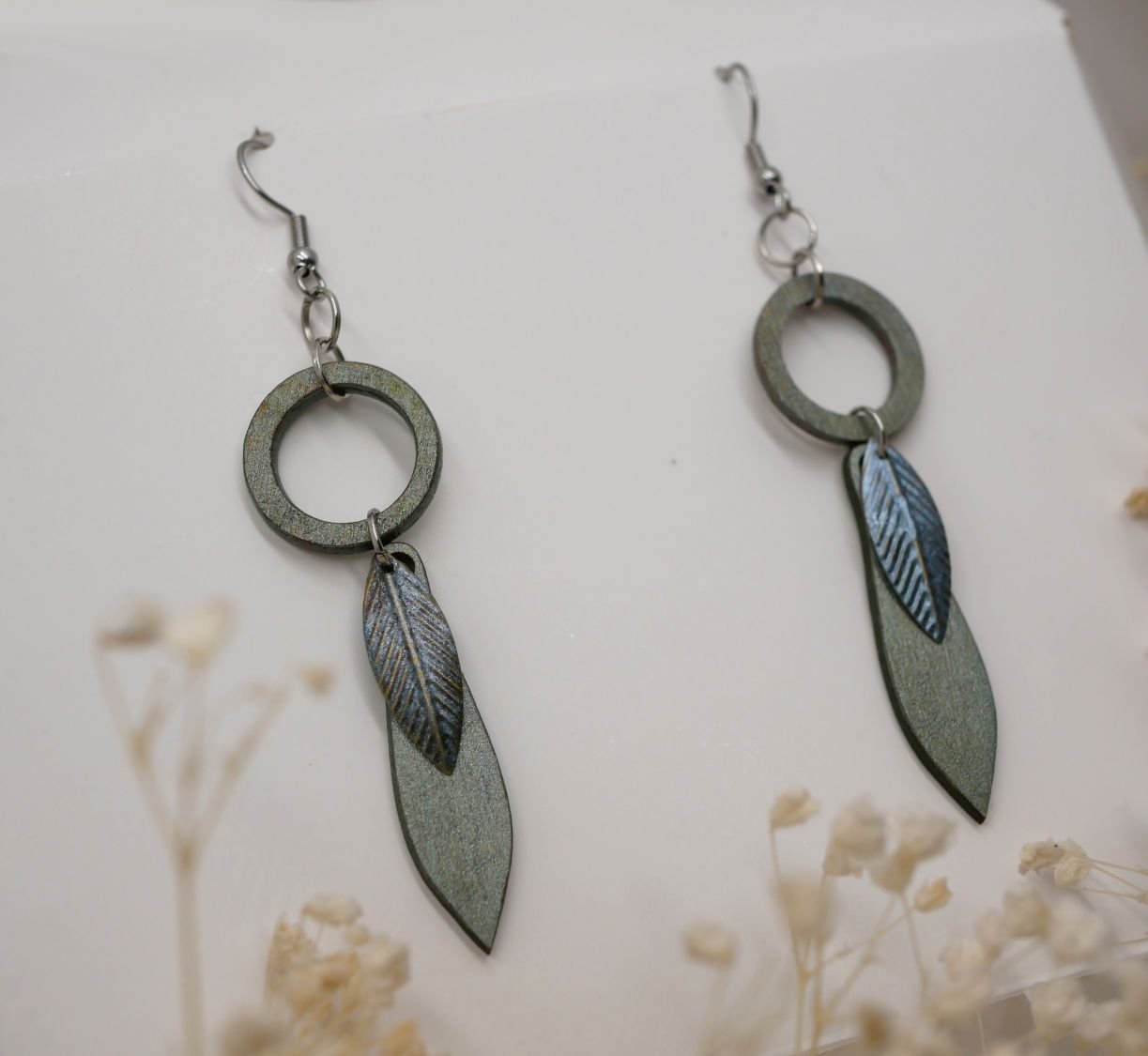 Leaf earrings made of wood and metal with a greenish-grey patina