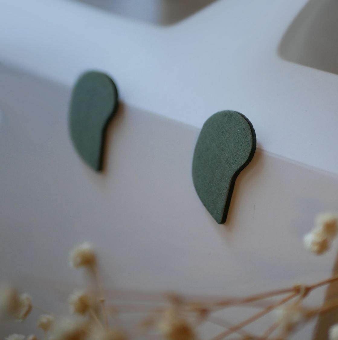 Graphic earrings in green wood with a metallic grey finish