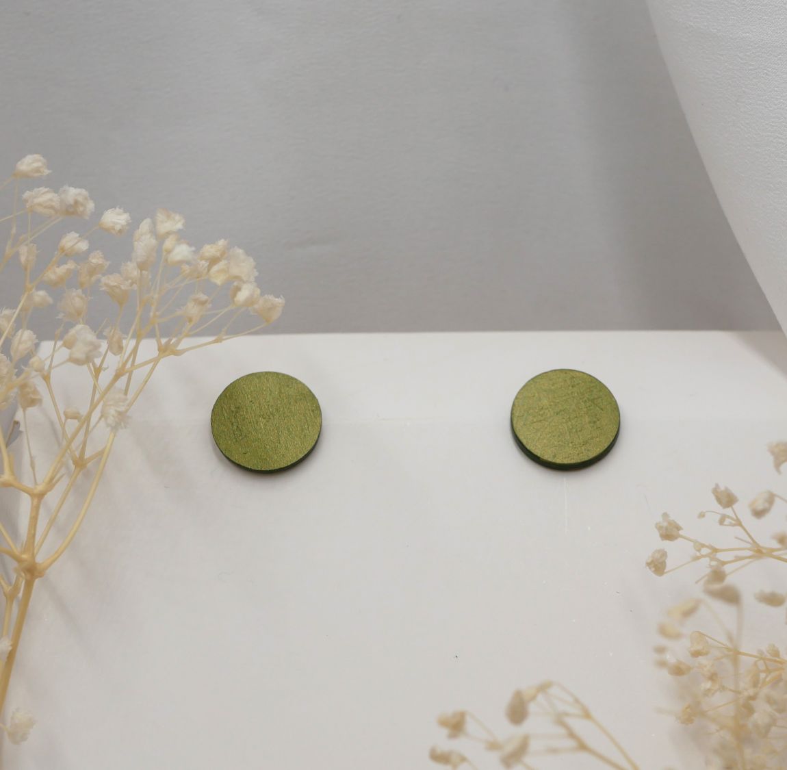 Round wooden earrings painted in green metallic effect