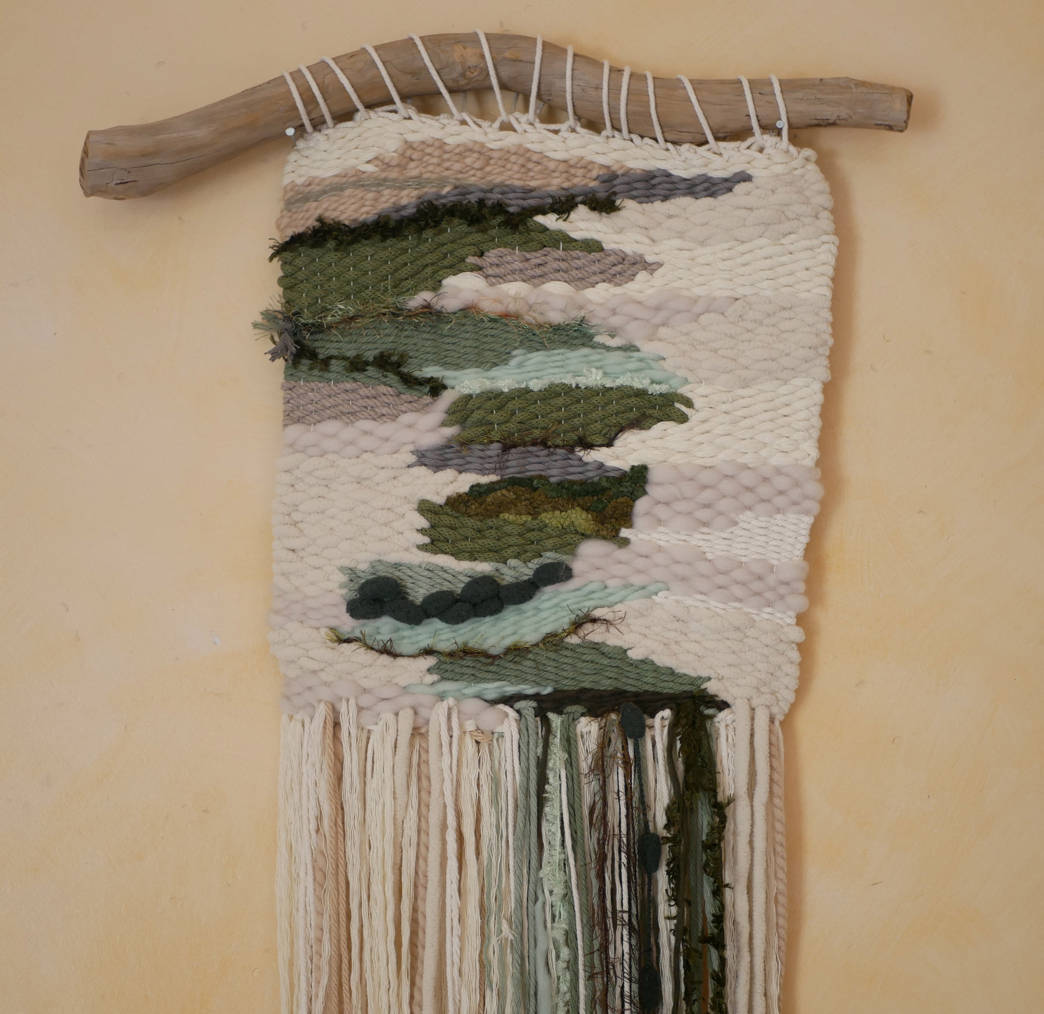 Suspension tissage mural "Les rivi&egrave;res v&eacute;g&eacute;tales" en laines et coton de couleurs vert d'eau et longues franges