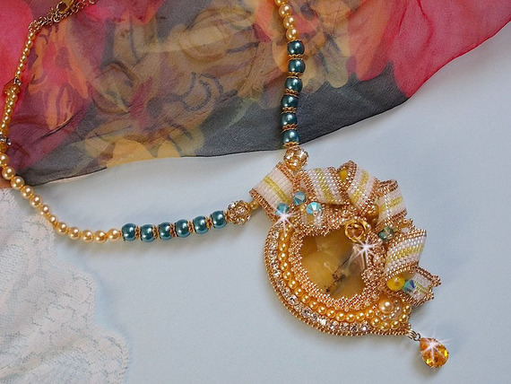 Haute-Couture Sunflower Gold pendant embroidered with 24 karat gold-plated seed beads, a Madagascar opal and Swarovski crystals.