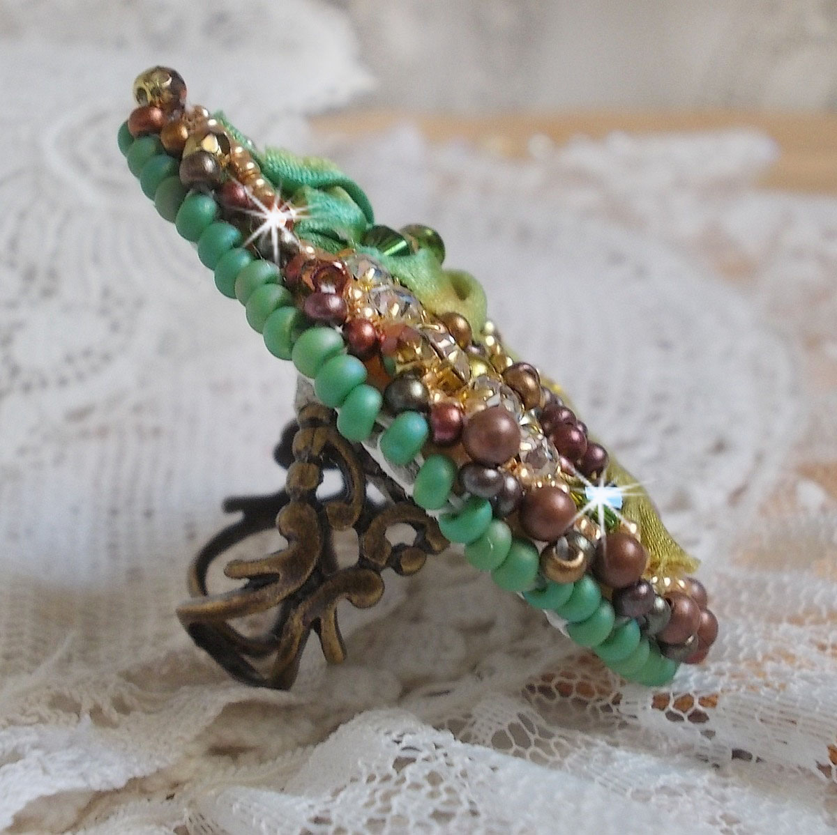 Venetian moon ring embroidered with a chameleon colored silk ribbon, Swarovski crystals, various pearls and seed beads