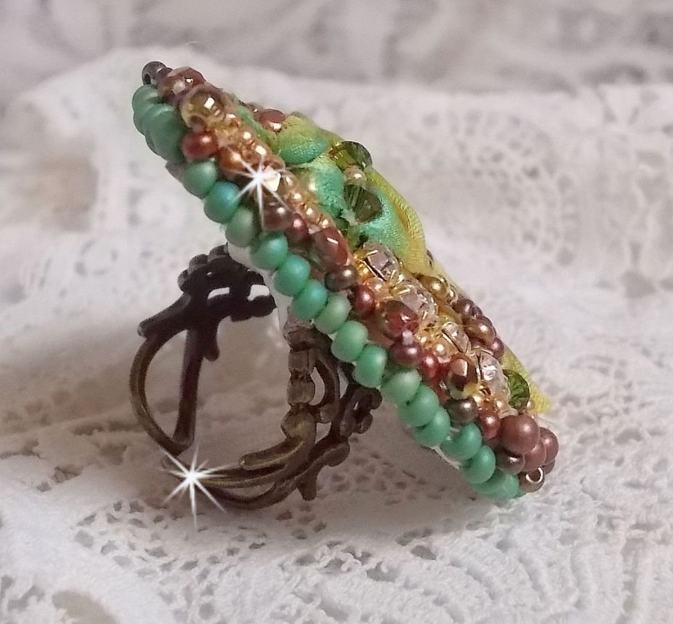 Venetian moon ring embroidered with a chameleon colored silk ribbon, Swarovski crystals, various pearls and seed beads