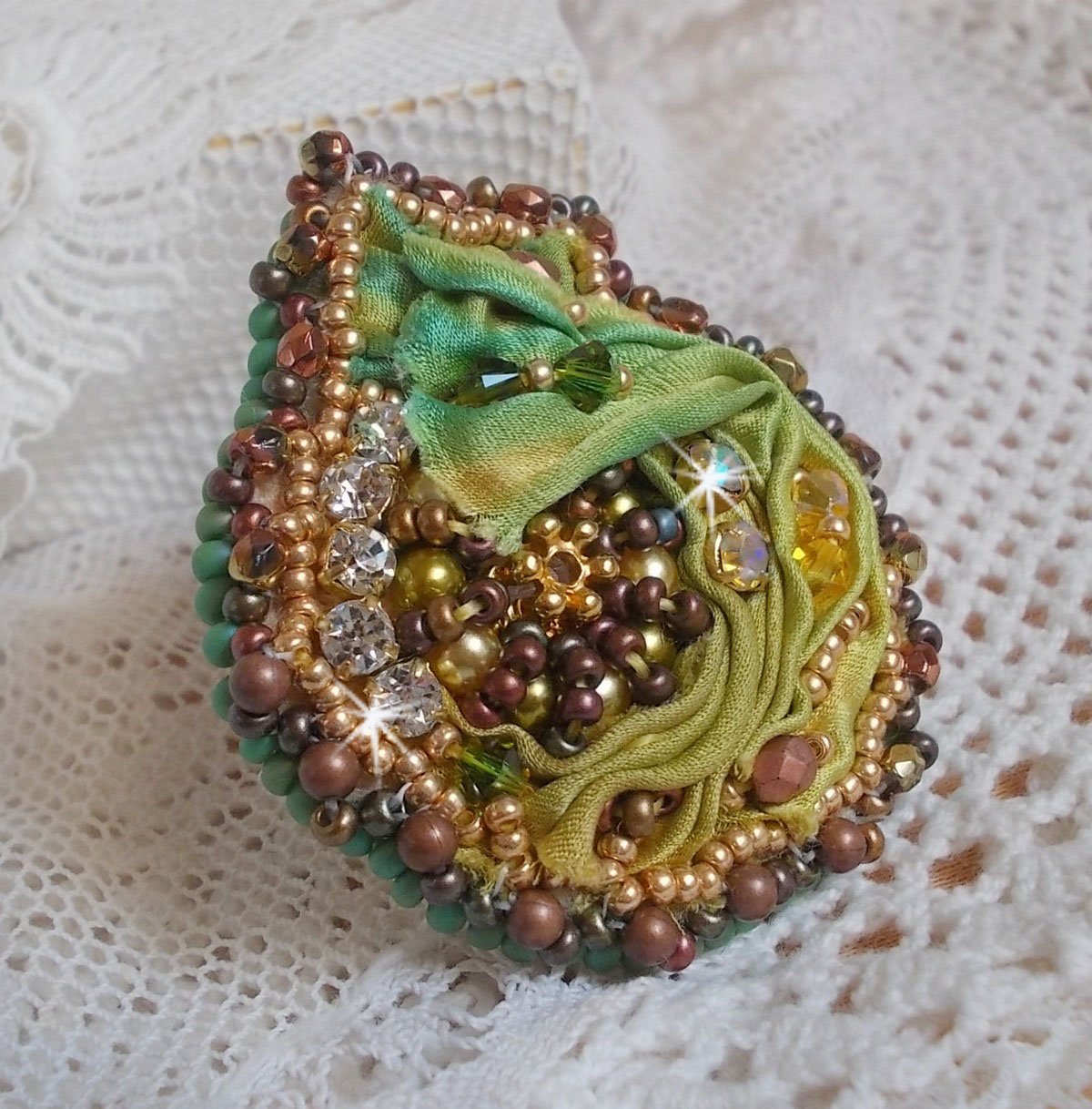 Venetian moon ring embroidered with a chameleon colored silk ribbon, Swarovski crystals, various pearls and seed beads