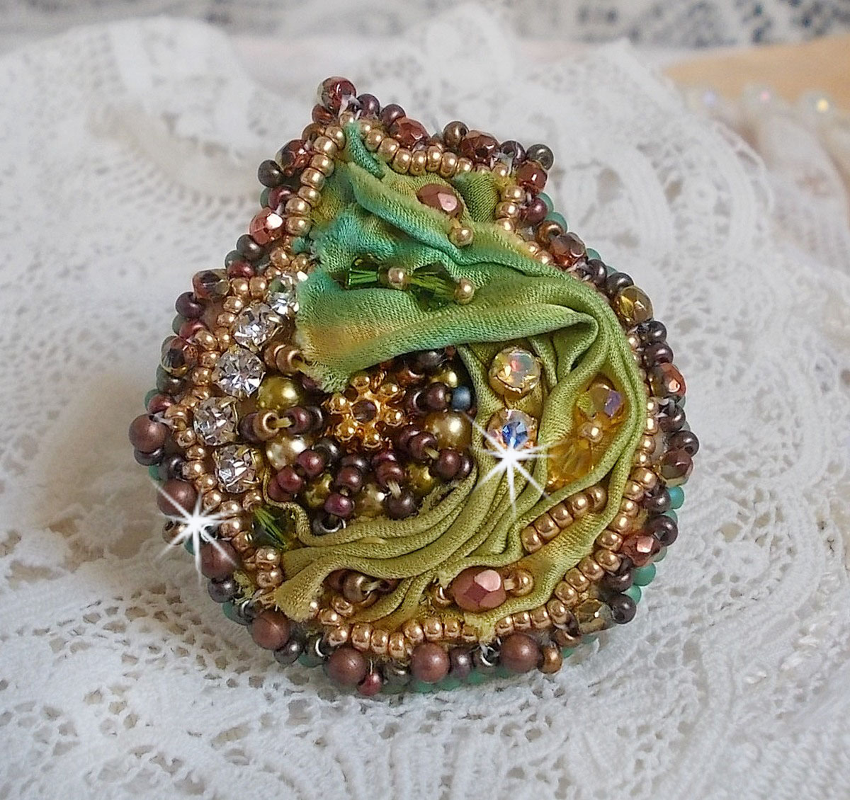 Venetian moon ring embroidered with a chameleon colored silk ribbon, Swarovski crystals, various pearls and seed beads