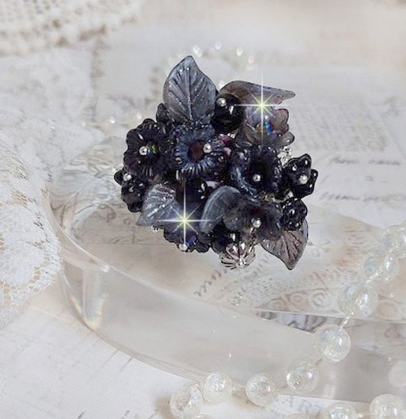 Bague Soir de Lune créée avec des fleurs lucites Noires et Grises peintes à la main, cristaux, perles en résine, perles en verre et coupelle argentée. Le tout est monté sur une bague argentée