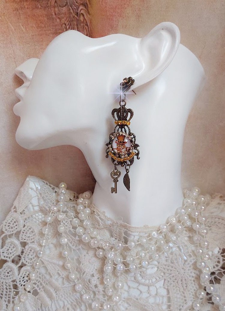 BO Chatibo Steampunk montées avec cabochons ronds en verre représentant un chat chapeauté Haute de Forme Orange. Strassées avec une couronne, breloques clés et feuilles. Montées sur clips Bronze