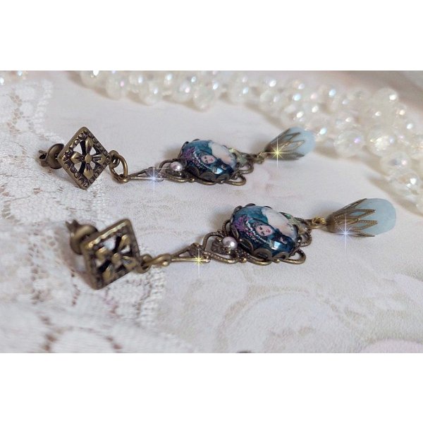 BO Dame au chapeau fleuri repr&eacute;sentant une femme au chapeau entour&eacute; d&rsquo;un ruban noir est mont&eacute; sur des estampes avec des n&oelig;uds en cristal. Une belle &eacute;l&eacute;gance avec ces gouttes en Jade teint&eacute;es de Bleu