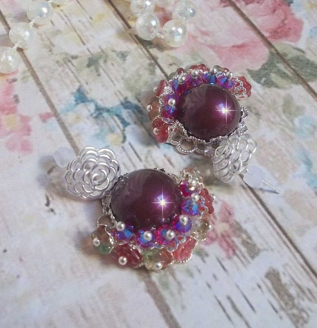 BO Fleurs de Cabaret avec des cabochons ronds Bordeaux en cristal de Swarovski, des toupies Fuschia, des fleurs clochettes en verre sur une base pendentif argentée et des clous d'oreilles en métal