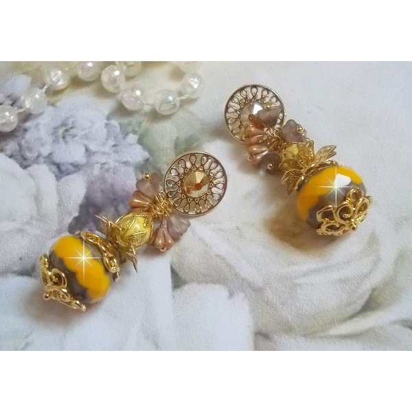 BO Lumi&egrave;re Opale Jaune avec des perles potirons jaunes &agrave; laquelle s&rsquo;ajoute des fleurs, cabochons en cristal, coupelles et perles rondes. Mont&eacute;s sur clous d&rsquo;oreilles en M&eacute;tal. Un style moderne