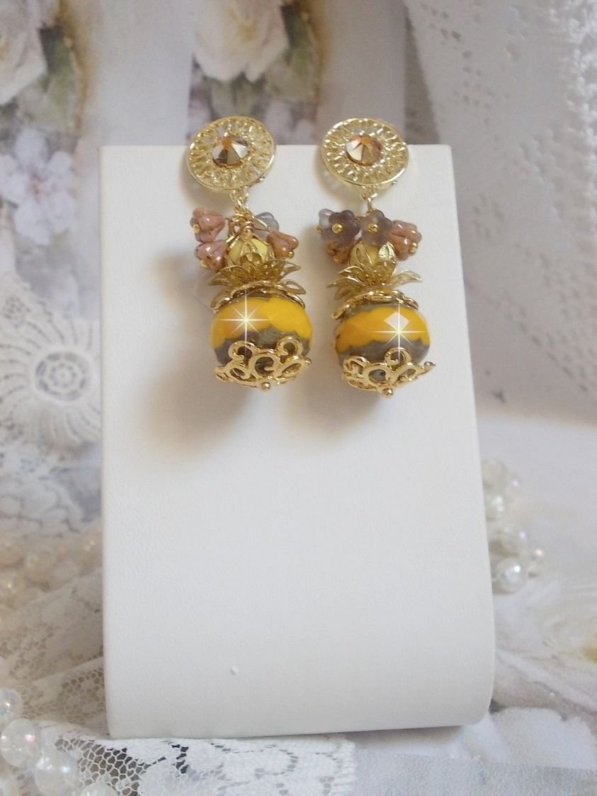 BO Lumière Opale Jaune avec des perles potirons jaunes à laquelle s’ajoute des fleurs, cabochons en cristal, coupelles et perles rondes. Montés sur clous d’oreilles en Métal. Un style moderne