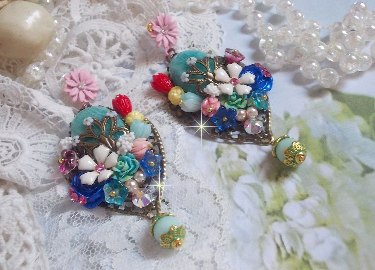 BO Majestueuses sur des estampes gouttes avec des cabochons aux fleurs vert, or, jaune, rouge, ivoire, cristal, rose et blanc. Les cristaux accompagnent l’ensemble des cabochons et perles en Amazonite