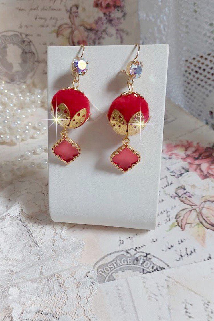 BO Passionnément montées avec des pompons Rouges très tendances à laquelle s’ajoute des coupelles en forme d’arabesque, pendentifs vitrail Rouge/Doré et cabochons en Cristal AB sur crochets en Laiton