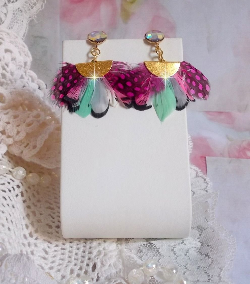 BO Plumis, Gris, Noir, Rose, Fuchsia et Menthe aux plumes de faisan et pintade avec des embouts demi-lune. Le tout est monté sur des clous d’oreilles en laiton avec des cabochons en cristal.