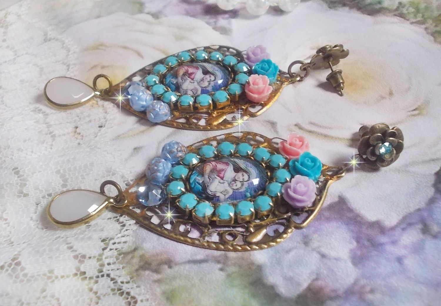 BO Vierge Marie et l’Enfant façon religieuse avec cabochons strassés couleur Turquoise, roses et cristaux. Montés sur estampes où j’ai appliqué une fine poudre Or. Une douceur avec les gouttes