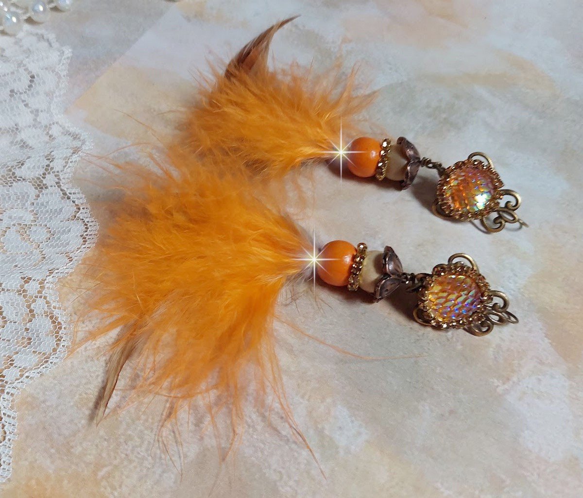 BO Vol au Vent créées avec plumes de pintade, Coq effet trois tons Beige, Marron et blanc, plumes Orange, perles bois naturel et Orange, perles résine et chaîne strass. Montées sur crochets en Laiton