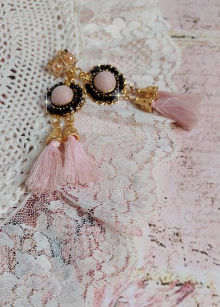 BO Rosy Rose mont&eacute;es avec des cabochons en tissu velours rose poudr&eacute; orn&eacute; d&rsquo;une cha&icirc;ne strass Cristal Noir sur estampes Dor&eacute;es en Laiton. S&rsquo;ajoute des pompons avec c&ocirc;nes M&eacute;tal sur clous en Argent 925