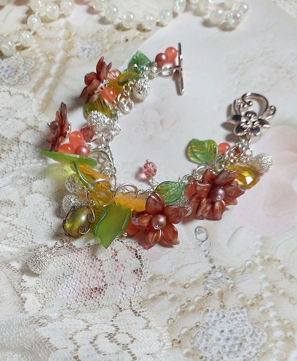 Bracelet Blondy créé sur un bracelet gourmette argenté d’un fermoir en T avec des fleurs et feuilles de saison à laquelle s’ajoute perles, cristaux, perle de Murano et perles en Jade teinté Orange