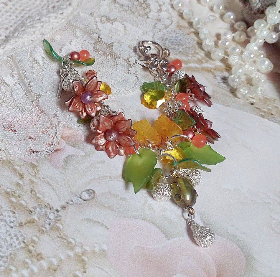 Bracelet Blondy créé sur un bracelet gourmette argenté d’un fermoir en T avec des fleurs et feuilles de saison à laquelle s’ajoute perles, cristaux, perle de Murano et perles en Jade teinté Orange