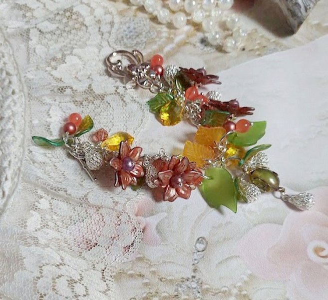 Bracelet Blondy créé sur un bracelet gourmette argenté d’un fermoir en T avec des fleurs et feuilles de saison à laquelle s’ajoute perles, cristaux, perle de Murano et perles en Jade teinté Orange