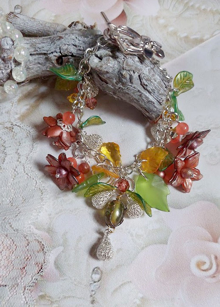 Bracelet Blondy créé sur un bracelet gourmette argenté d’un fermoir en T avec des fleurs et feuilles de saison à laquelle s’ajoute perles, cristaux, perle de Murano et perles en Jade teinté Orange