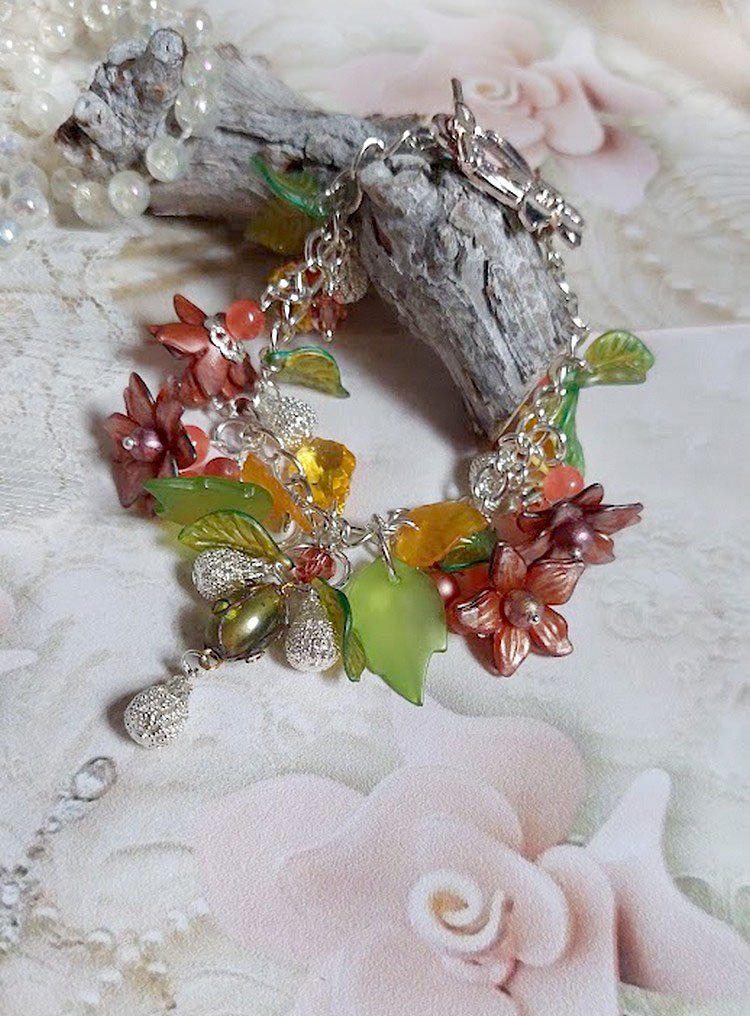 Bracelet Blondy créé sur un bracelet gourmette argenté d’un fermoir en T avec des fleurs et feuilles de saison à laquelle s’ajoute perles, cristaux, perle de Murano et perles en Jade teinté Orange