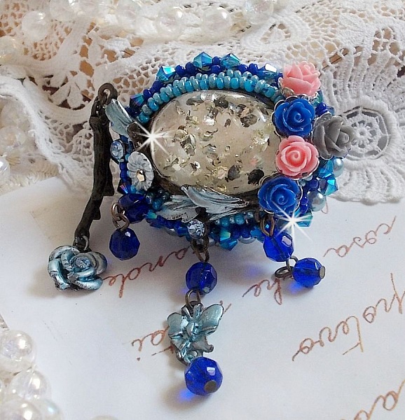 Broche Ang&eacute;line baroque tr&egrave;s ancienne relook&eacute;e sur une broderie avec un tr&egrave;s ancien cabochon en verre, des roses en r&eacute;sine et des rocailles