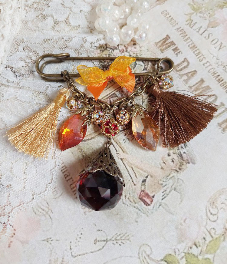Broche Méline des Bois épingle créée avec rondes strass, pompons, gouttes verre, chaîne et boule de bohème en verre