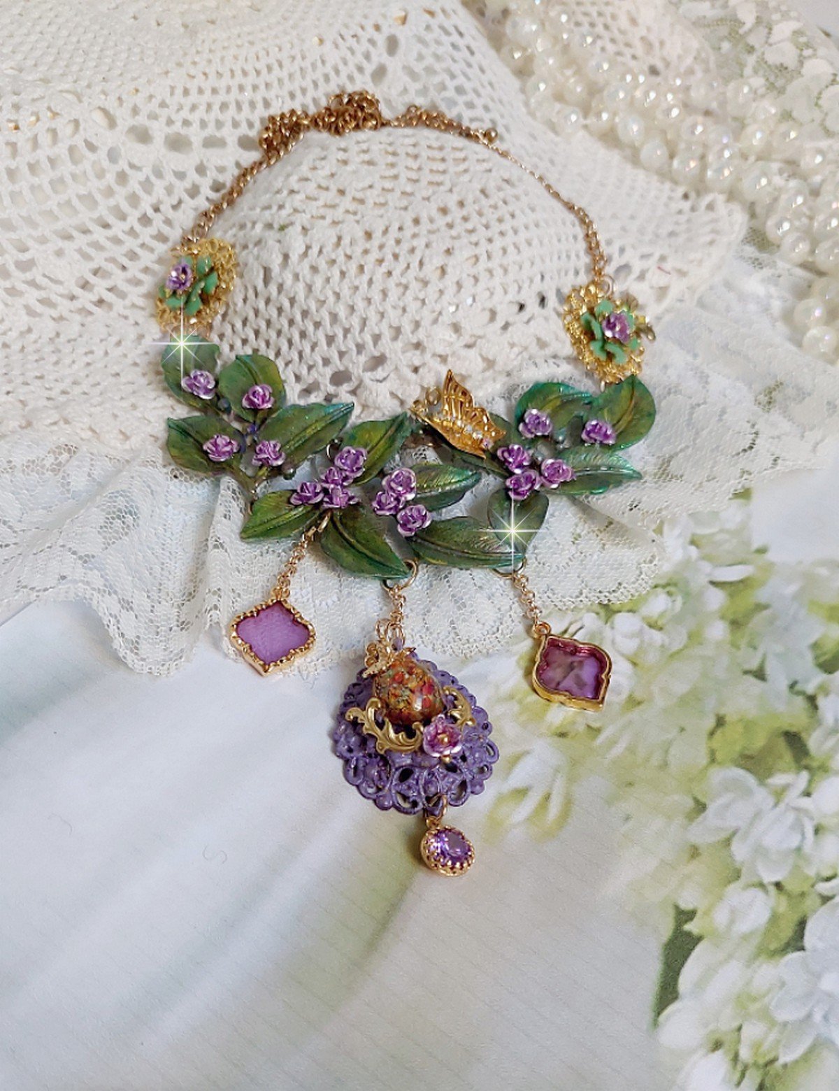 Collier Camélia Japonica monté avec un motif feuilles aquarellés à la main, paillettes, breloques papillons et abeille, roses métal, cabochon cristal, pendentifs époxy aux couleurs d’arc en ciel