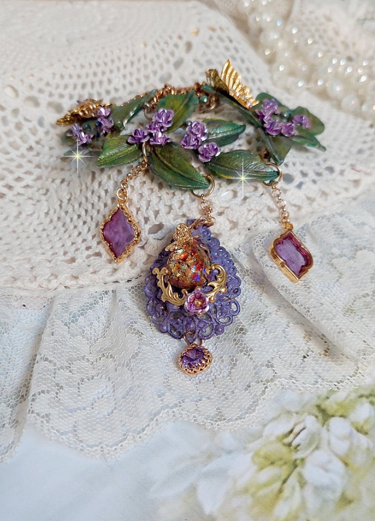 Collier Camélia Japonica monté avec un motif feuilles aquarellés à la main, paillettes, breloques papillons et abeille, roses métal, cabochon cristal, pendentifs époxy aux couleurs d’arc en ciel