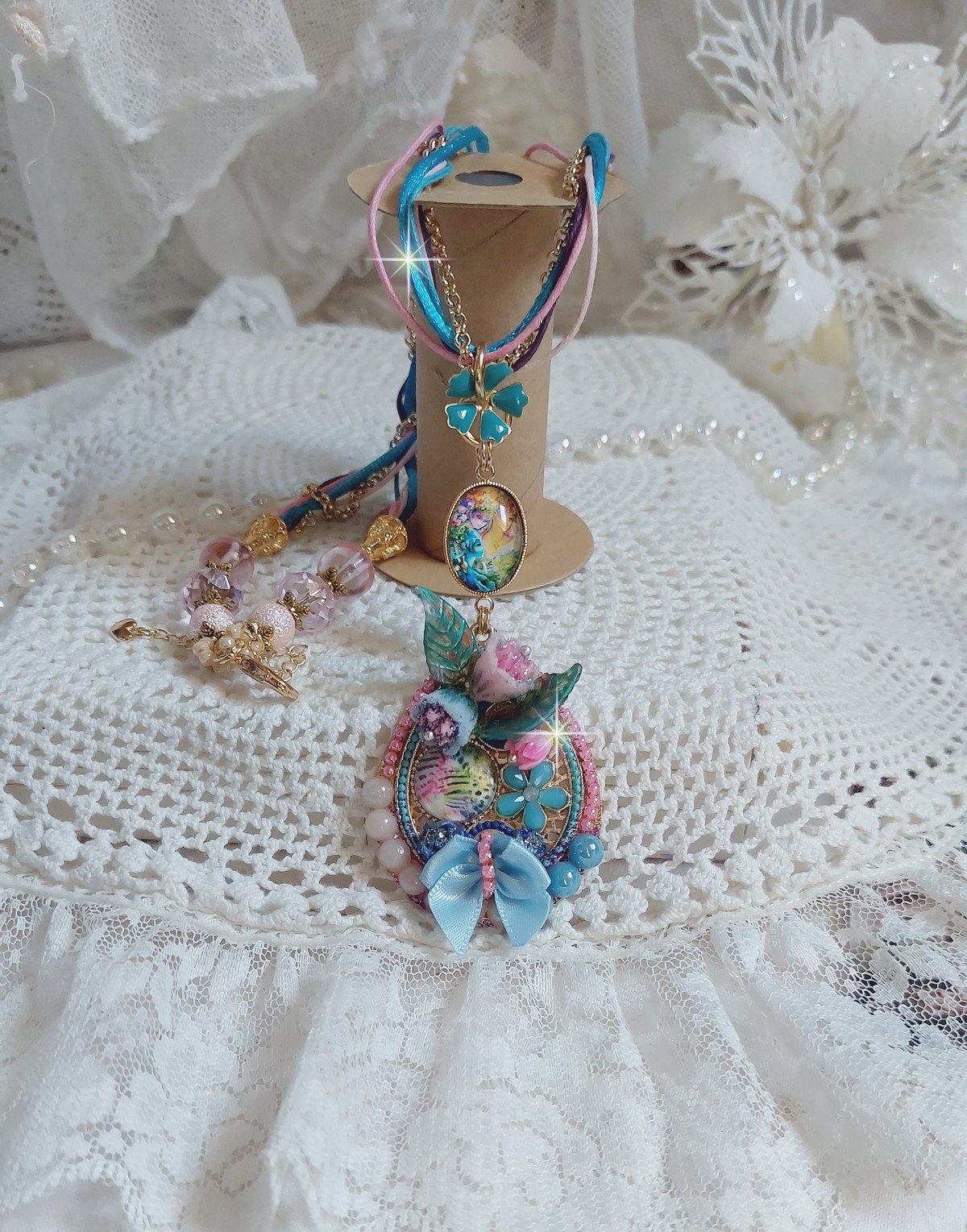  Collier Coquette créé avec deux estampes à laquelle s’ajoute des fleurs en velours floqué, perles aplaties Cristal, fleurs : Epoxy, Porcelaine, Résine, cabochon loupe, rubans et chaîne plaqué Or