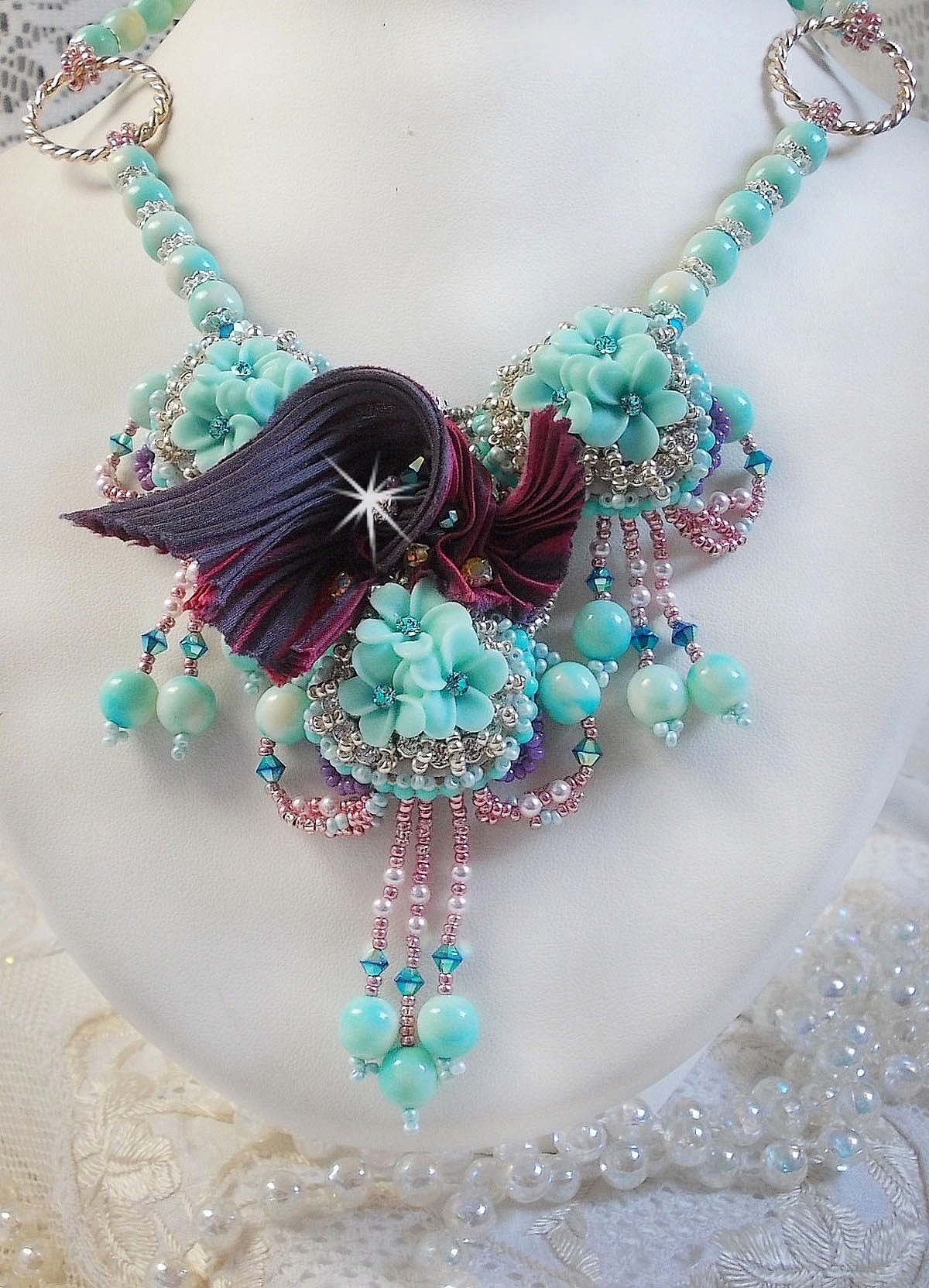 Blue Flowers Haute-Couture necklace embroidered with Swarovski crystals, a silk ribbon in Truffle/Raspberry color and seed beads