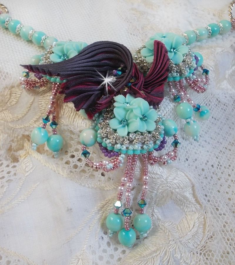 Blue Flowers Haute-Couture necklace embroidered with Swarovski crystals, a silk ribbon in Truffle/Raspberry color and seed beads