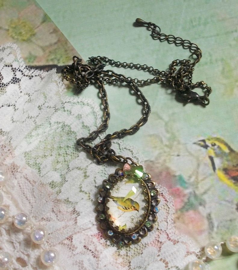 Bird of the Gardens necklace created with a magnifying glass cabochon and crystals mounted on bronze accessories