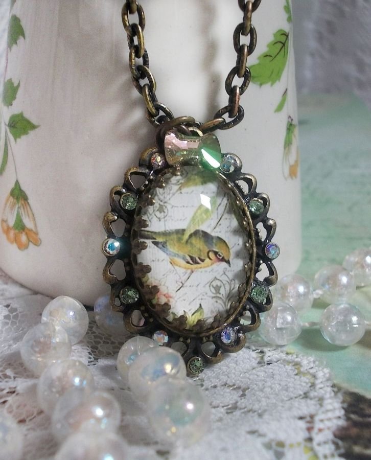 Bird of the Gardens necklace created with a magnifying glass cabochon and crystals mounted on bronze accessories