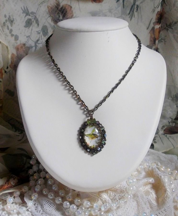 Bird of the Gardens necklace created with a magnifying glass cabochon and crystals mounted on bronze accessories