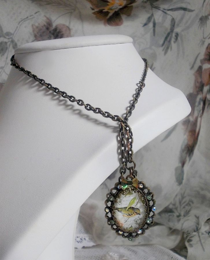 Bird of the Gardens necklace created with a magnifying glass cabochon and crystals mounted on bronze accessories