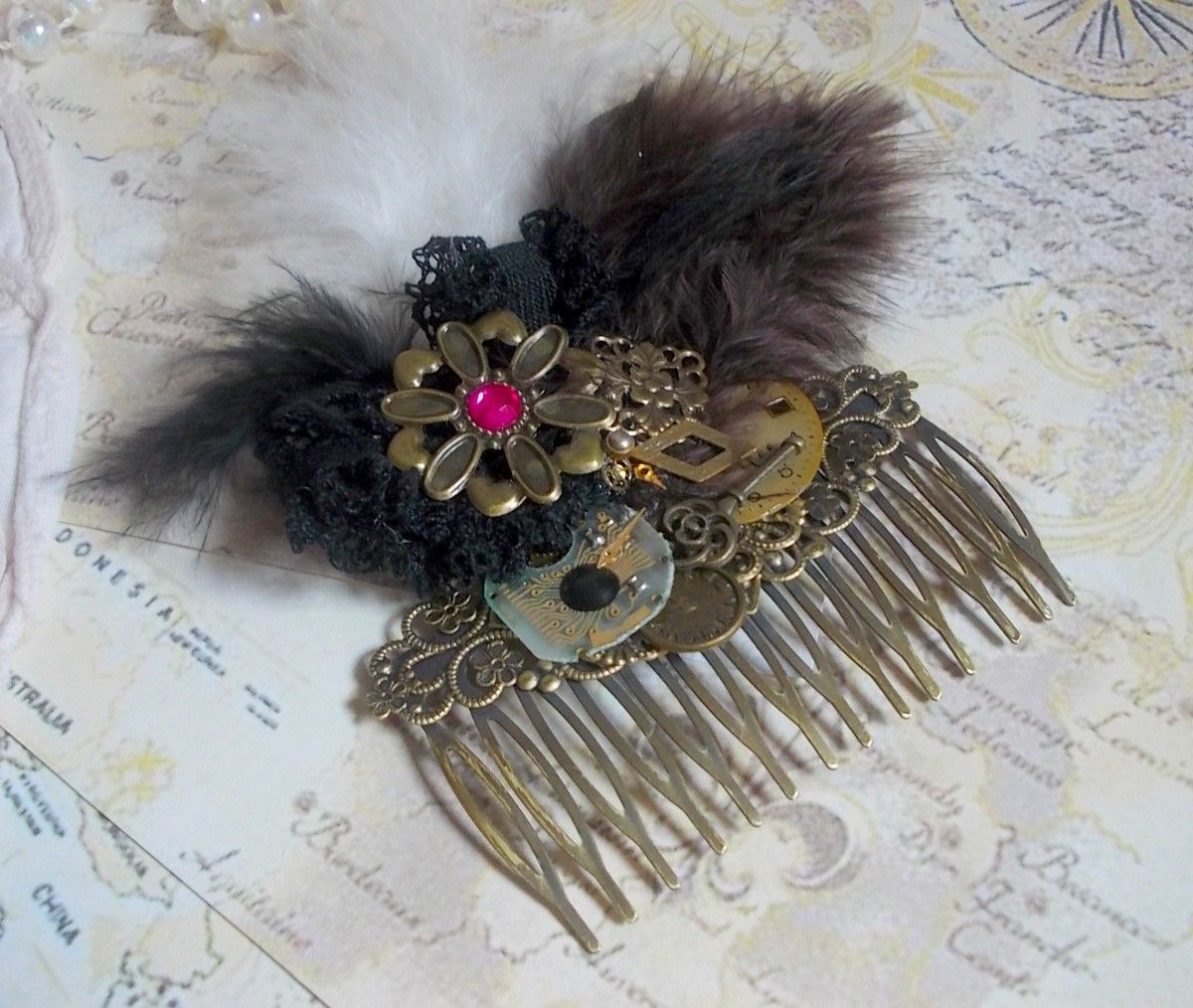 Curiosity Time hair comb created with black lace, various accessories, charms of gold, silver, bronze colors with black, brown and white feathers