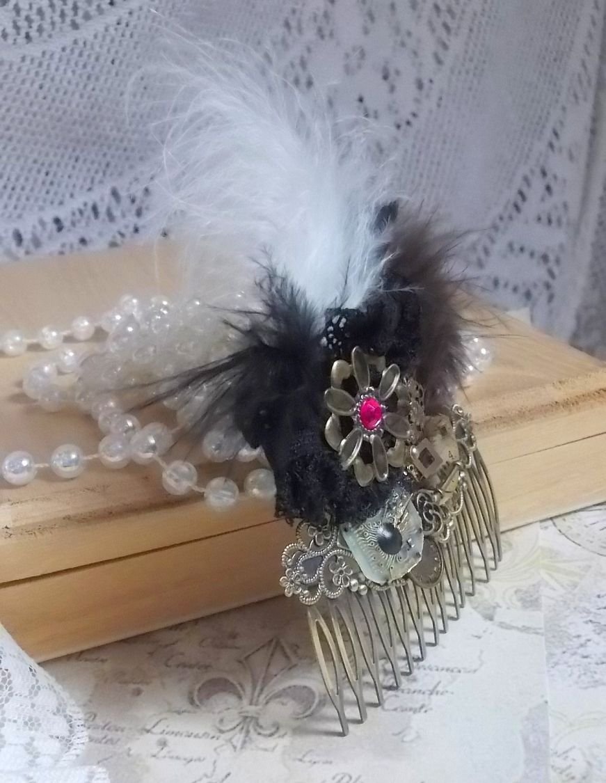 Curiosity Time hair comb created with black lace, various accessories, charms of gold, silver, bronze colors with black, brown and white feathers