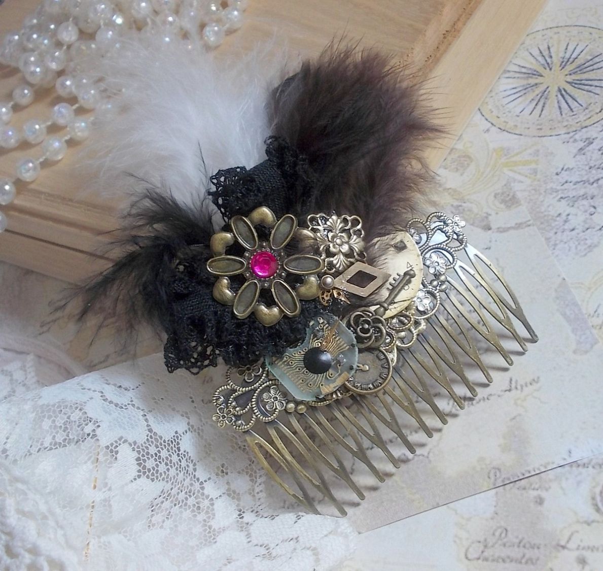 Curiosity Time hair comb created with black lace, various accessories, charms of gold, silver, bronze colors with black, brown and white feathers