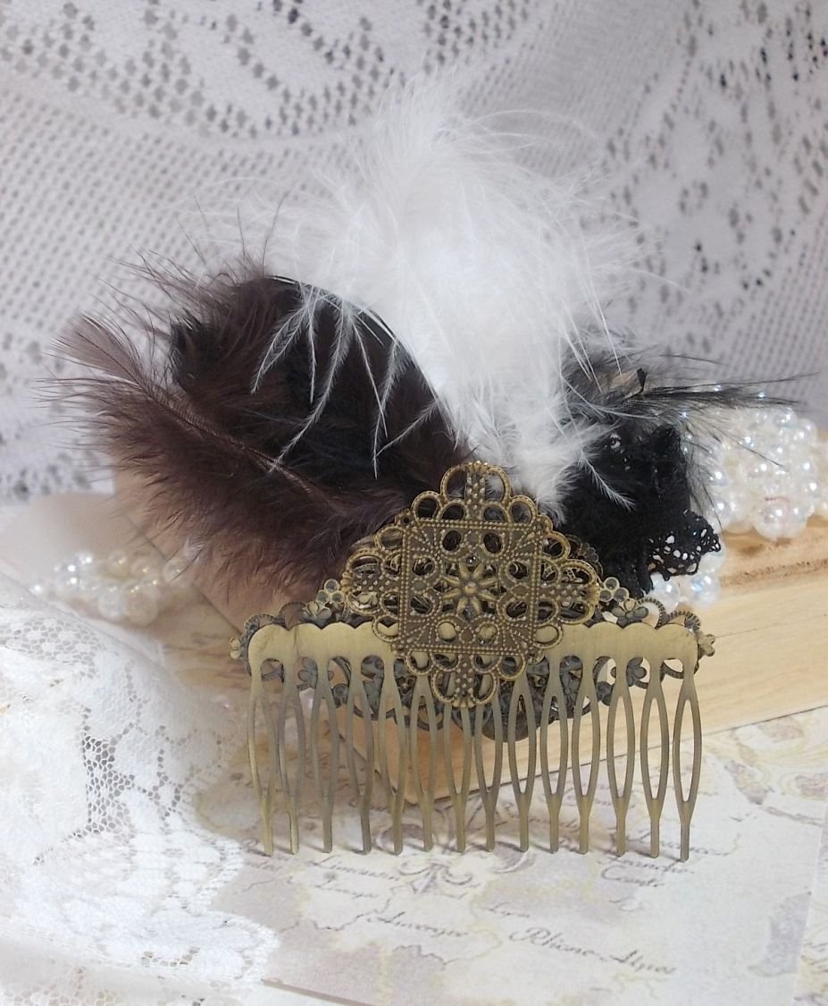 Curiosity Time hair comb created with black lace, various accessories, charms of gold, silver, bronze colors with black, brown and white feathers