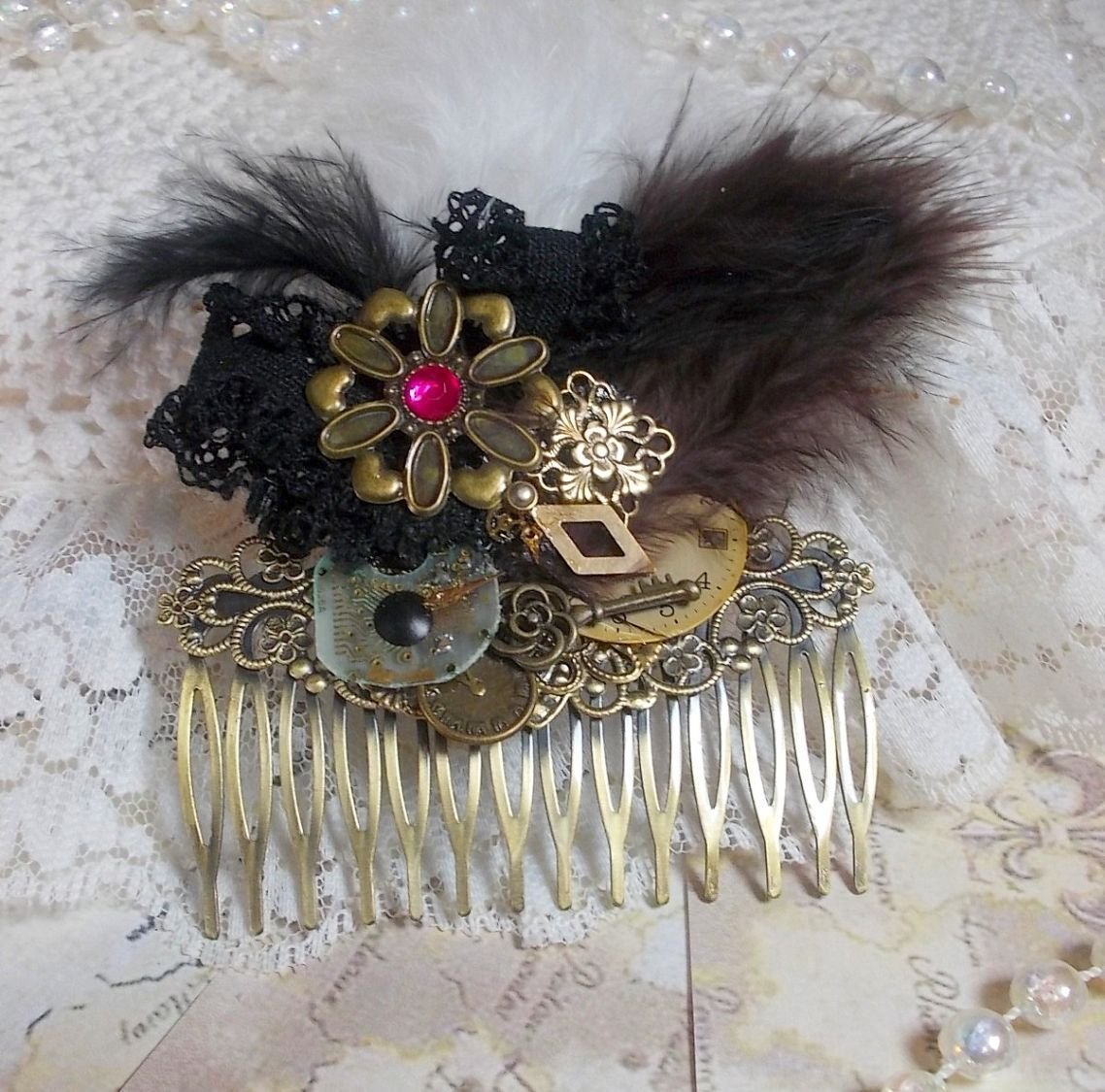 Curiosity Time hair comb created with black lace, various accessories, charms of gold, silver, bronze colors with black, brown and white feathers